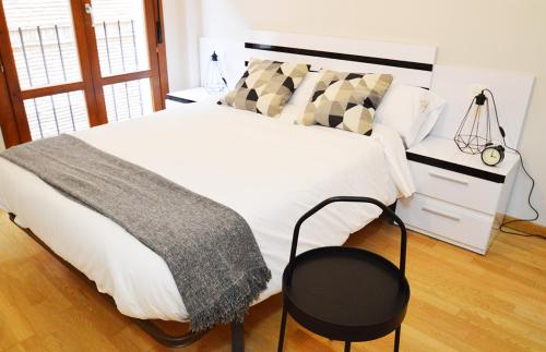 塔拉桑纳阿拉贡Apartamento Encanto Tarazona Plaza de España的卧室配有一张白色大床和黑椅