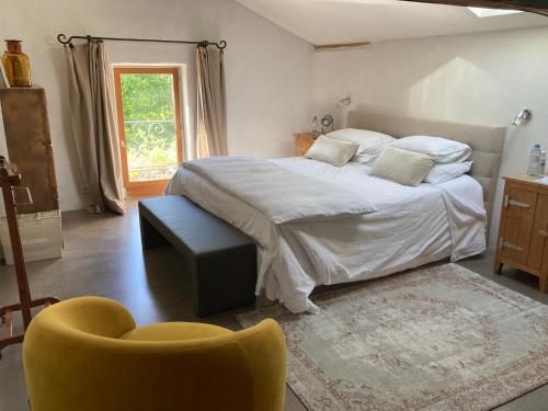 GenayL'Angélus的一间卧室配有一张大床和一张黄色椅子
