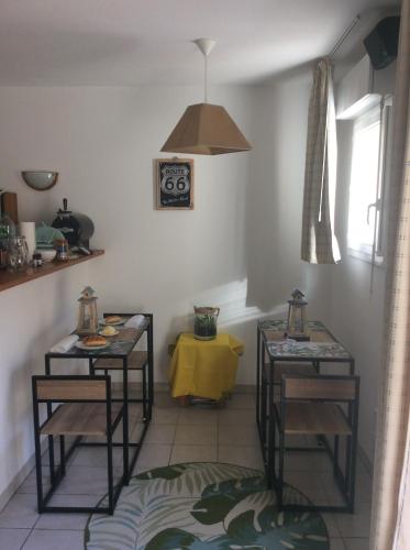 滨海苏拉克Résidence domaine des sables ROUTE 66的一间设有两张桌子和一张黄色桌子的房间