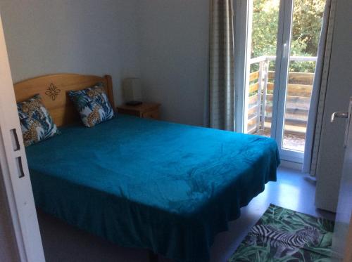 滨海苏拉克Résidence domaine des sables ROUTE 66的一间卧室配有一张带蓝色床罩的床