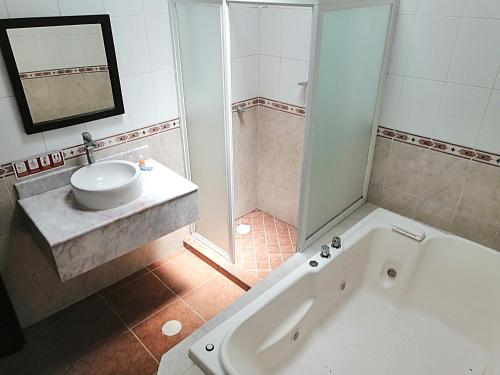瓜达拉哈拉阿卡勒斯汽车旅馆的带浴缸、水槽和淋浴的浴室