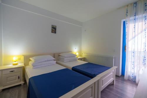茹里洛夫卡Pensiunea Dolosman的一间卧室配有两张带蓝白色床单的床