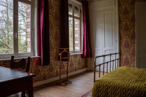HargicourtSfeervolle b&b Le Moulin de la Place的卧室配有床、桌子和窗户。