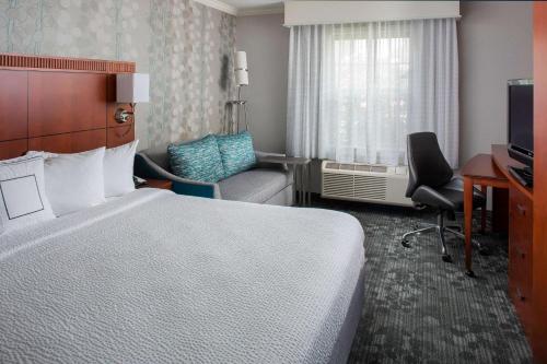 洛厄尔波士顿罗威尔切姆斯福德庭院酒店的配有一张床和一把椅子的酒店客房