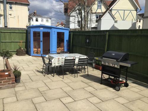 伯恩茅斯Rockmount Court的一个带烧烤架和桌椅的庭院