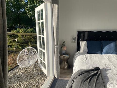 亚伯Farm Stay HARMONY Cottage at Wilindi Estate的卧室设有一扇门,可通往带一张床的阳台