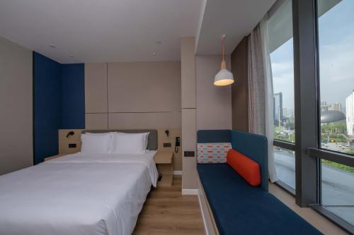 重庆重庆彩云湖智选假日酒店的一间卧室配有一张床、一张沙发和一个窗口