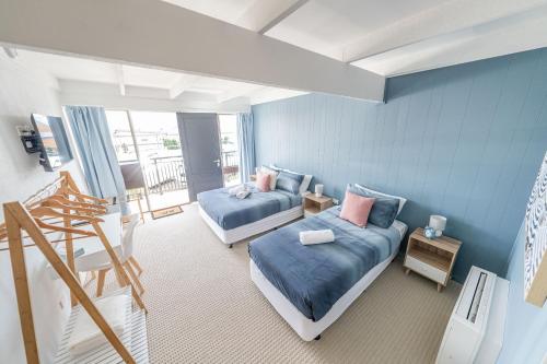 伊登Coast Motel Eden的一间蓝色客房,设有两张床和楼梯