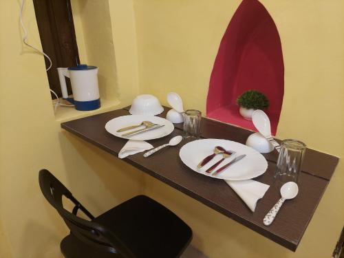 加尔各答Ani's Homestay的一张桌子,上面有盘子和餐具,还有镜子