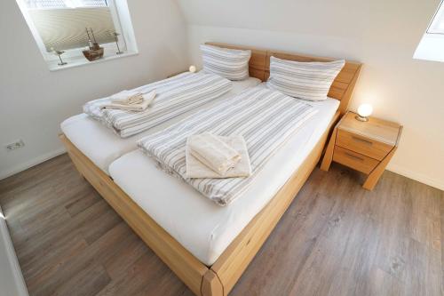 卡罗利嫩西尔Ferienhaus Lüttje Krabbe的一间卧室配有一张床,上面有两条毛巾