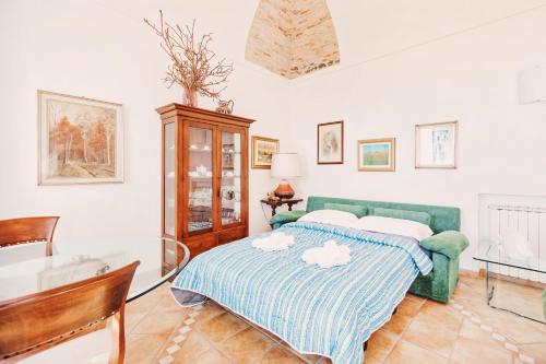 欧斯佩达蒂Appartamento fronte mare a Ospedaletti by Wonderful Italy的一间卧室配有一张绿色的床和一张桌子