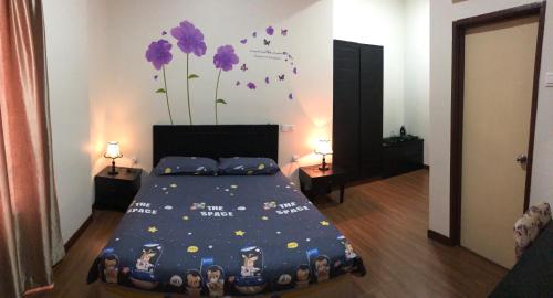 马六甲Homestay at Lagoon Park Resort的卧室配有一张墙上紫色鲜花的床