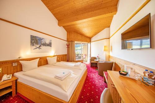 弗利姆斯T3 Alpenhotel Flims的一间卧室,卧室内配有一张大床