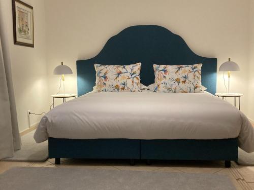费雷拉斯Villa Tranberg Suites的一间卧室配有一张大床和蓝色床头板