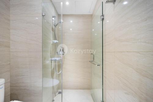 雅加达SOLEIL by Kozystay Kemang的浴室里设有玻璃门淋浴