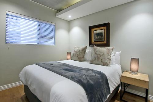 开普敦Docklands Deluxe One bedroom Apartments的卧室设有一张白色大床和一扇窗户。
