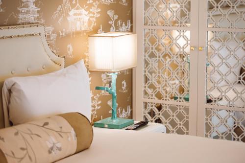 伦敦伦敦多塞特牧羊人布什酒店的一间卧室配有一张带台灯的床铺,