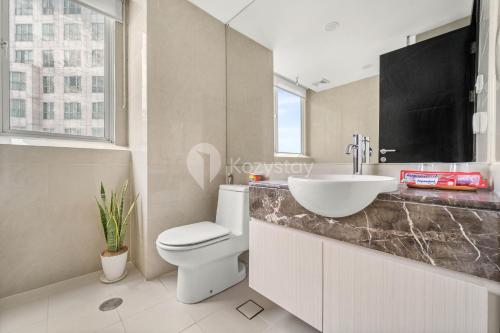 雅加达Castille by Kozystay - Gandaria的浴室配有白色卫生间和盥洗盆。