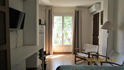 尼斯NICE - STUDIO indépendant en VILLA - Mer ville calme jardinet的客厅设有大窗户和椅子