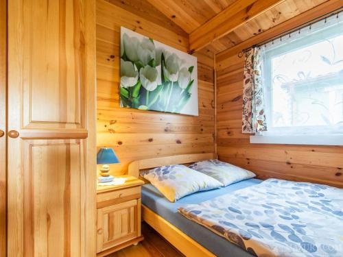 米科瓦伊基Domki Romka的小木屋内一间卧室,配有一张床