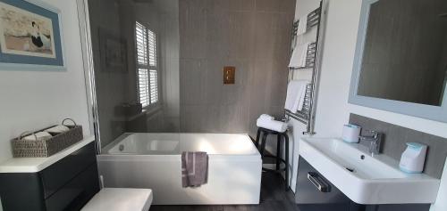 贝弗利37 Trinity Lane的白色的浴室设有浴缸和水槽。