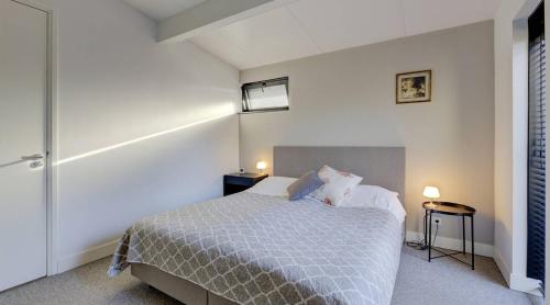 BeuningenOlde Kottink的一间卧室配有一张床、两张桌子和两盏灯。