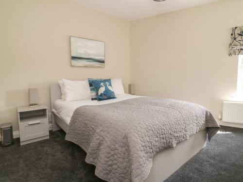 莫尔顿6 Church Hill的一间卧室配有一张带蓝色枕头的床
