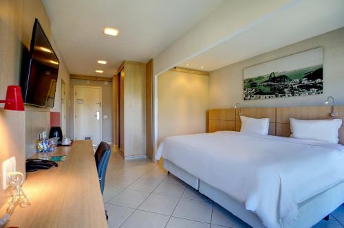 里约热内卢里约热内卢巴拉达蒂茹卡品质酒店 的卧室配有一张白色大床和一张书桌