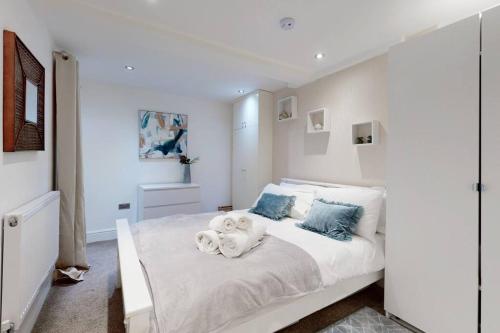 伦敦Lovely 2 Bedroom Apartment near Highgate Station的卧室配有白色的床,里面装满了动物