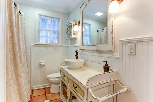 费南迪纳比奇Ocean Ave Seaside Cottage的一间带水槽、卫生间和镜子的浴室