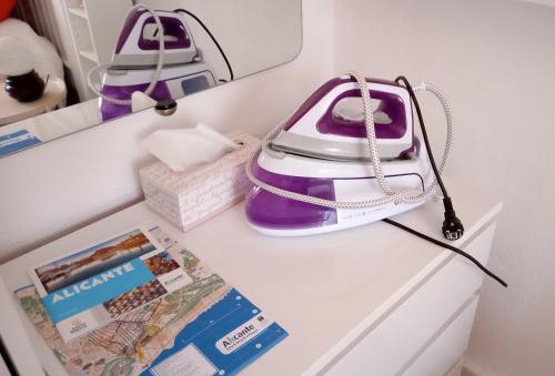 阿利坎特Habitación con baño privado en piso familiar的紫色和白色的钱包,放在冰箱顶