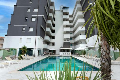 里米尼Nero D'Avorio Aparthotel & SPA的大楼前设有游泳池的酒店