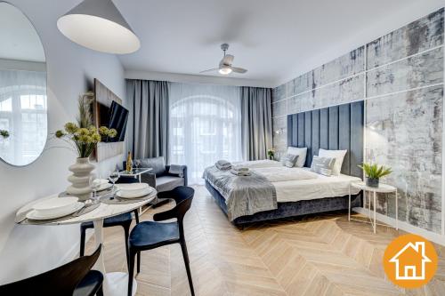 斯维诺乌伊希切Apartamenty Promenada - visitopl的卧室配有一张床和一张桌子及椅子