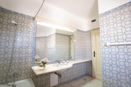 阿尔布费拉Pateo Apartments的蓝色的浴室设有水槽和镜子