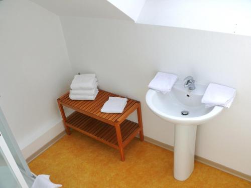 维桑Hôtel Le Vivier WISSANT - Rivière的浴室配有水槽和毛巾及桌子