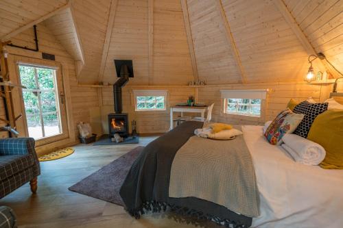 CarlukePunch Tree Cabins Couples Outdoor Bath的带壁炉的客房内的一间卧室配有一张床