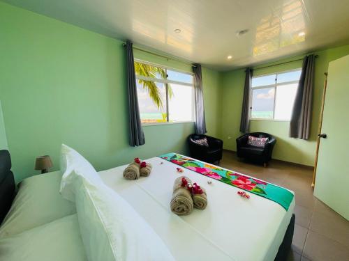 波拉波拉Matira Beach Bungalow Waterfront的卧室配有带鞋的大型白色床