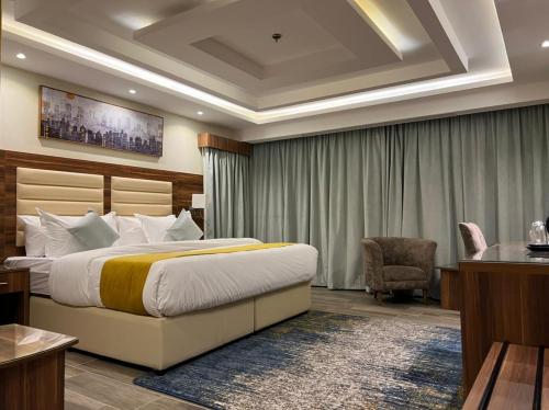 吉达Moments Hotel的配有一张床和一把椅子的酒店客房