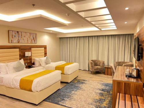 吉达Moments Hotel的酒店客房设有两张床和电视。