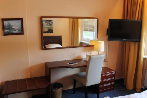 亨施泰特-乌尔茨堡维京酒店的酒店客房配有书桌和镜子