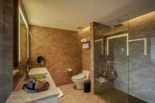 日惹Amaranta Prambanan Yogyakarta的一间带卫生间和玻璃淋浴间的浴室
