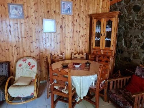 卡洛帕尼亚伊奥蒂斯Elpiniki's Old House的一间带木桌和椅子的用餐室