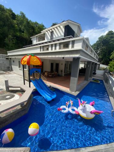 峇六拜20PAX 4BR Villa with Kids Swimming Pool, KTV, Pool Table n BBQ near SPICE Arena Penang的一座房子,里面设有游泳池,里面装有玩具