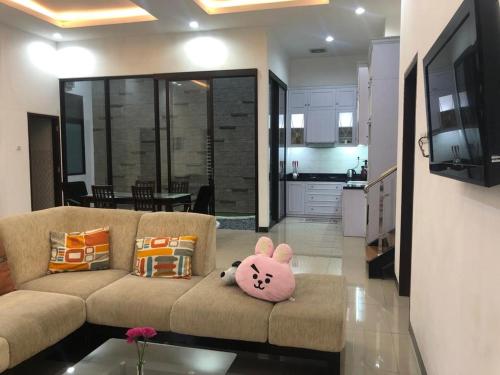 Kepiting-kidulNew 3br The Green Home的客厅配有带小猫枕头的沙发