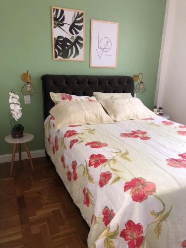 彼得罗波利斯Apartamento Centro Histórico de Petrópolis 200Mbps de internet的一间卧室配有一张带花卉床罩的床