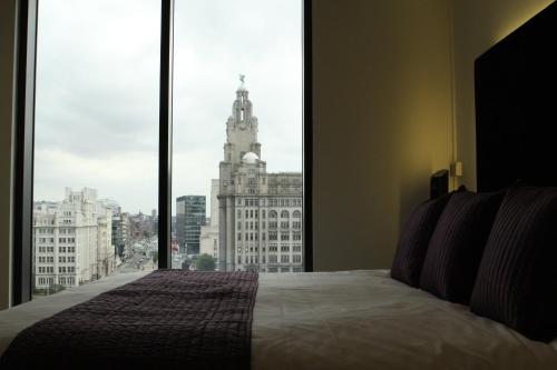 利物浦Liver View Apartments的一间卧室设有一张床,享有建筑的景色