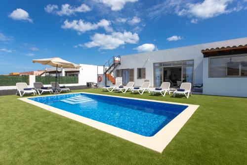 卡勒达德福斯特Luxury Villa Perla的后院设有游泳池、椅子和房屋