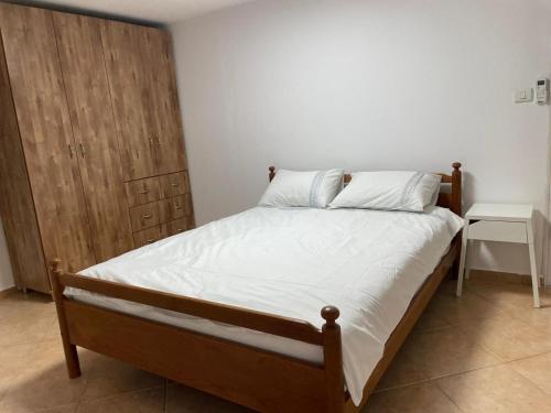 舍亚尔雅舒弗אל מול חרמון- דירה באווירה כפרית עם נוף לחרמון的一间卧室配有一张床和一个木制橱柜