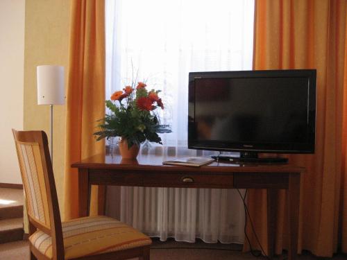 阿尔特廷阿尔施塔特舍科斯酒店的坐在房间桌子上的电视