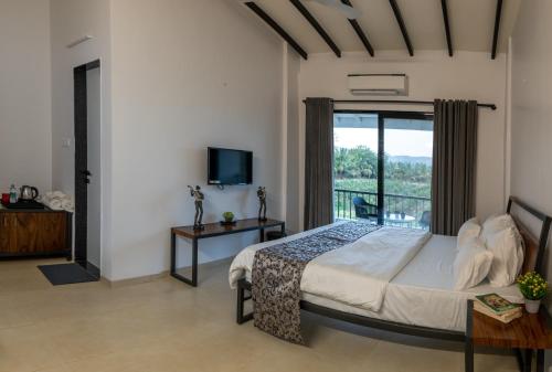 纳西克The Green Estate Resort的一间卧室设有一张床和一个阳台